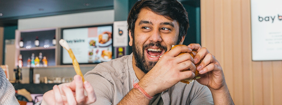 A student eating a burger with friends 