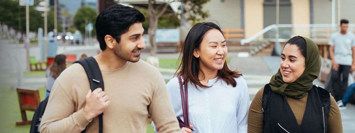 3 students walking and talking to each other