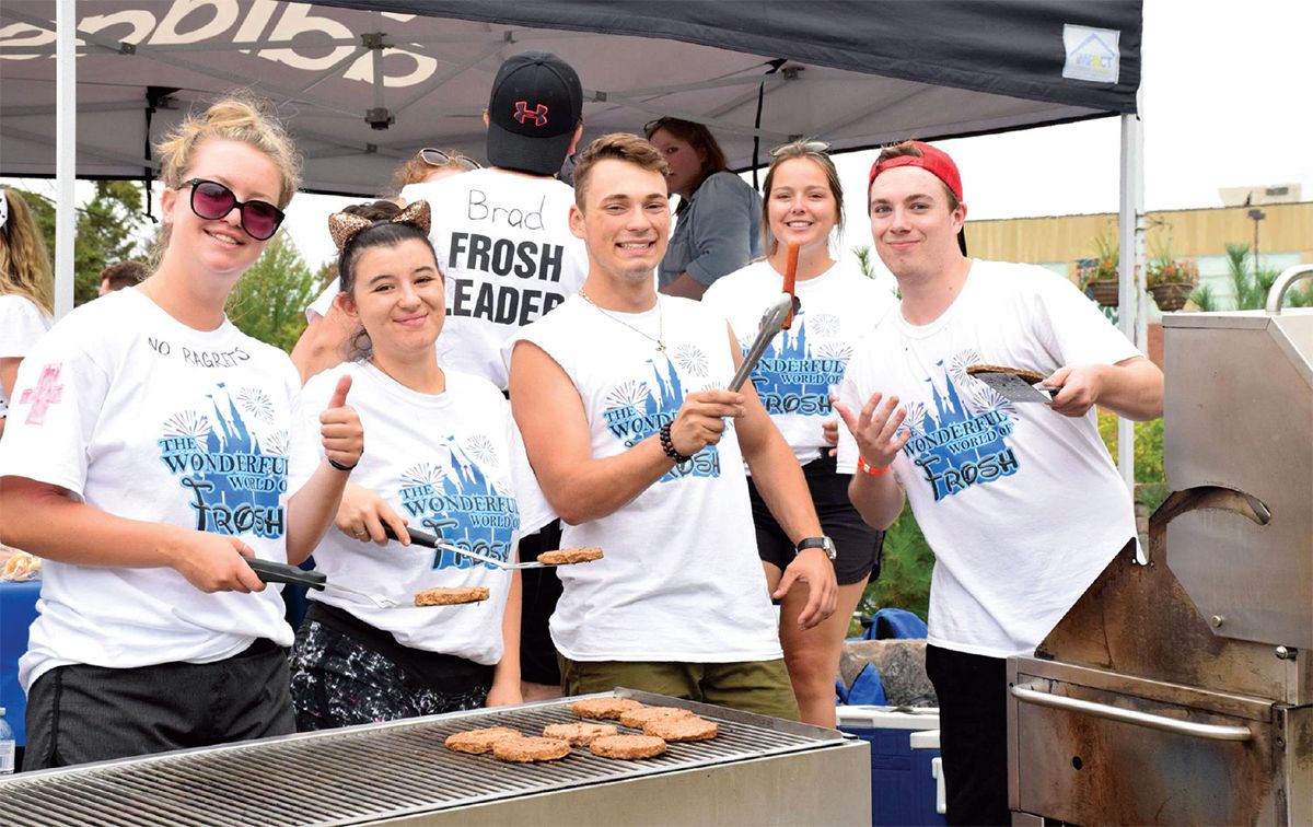 a group of students barbecuing and posing for picture