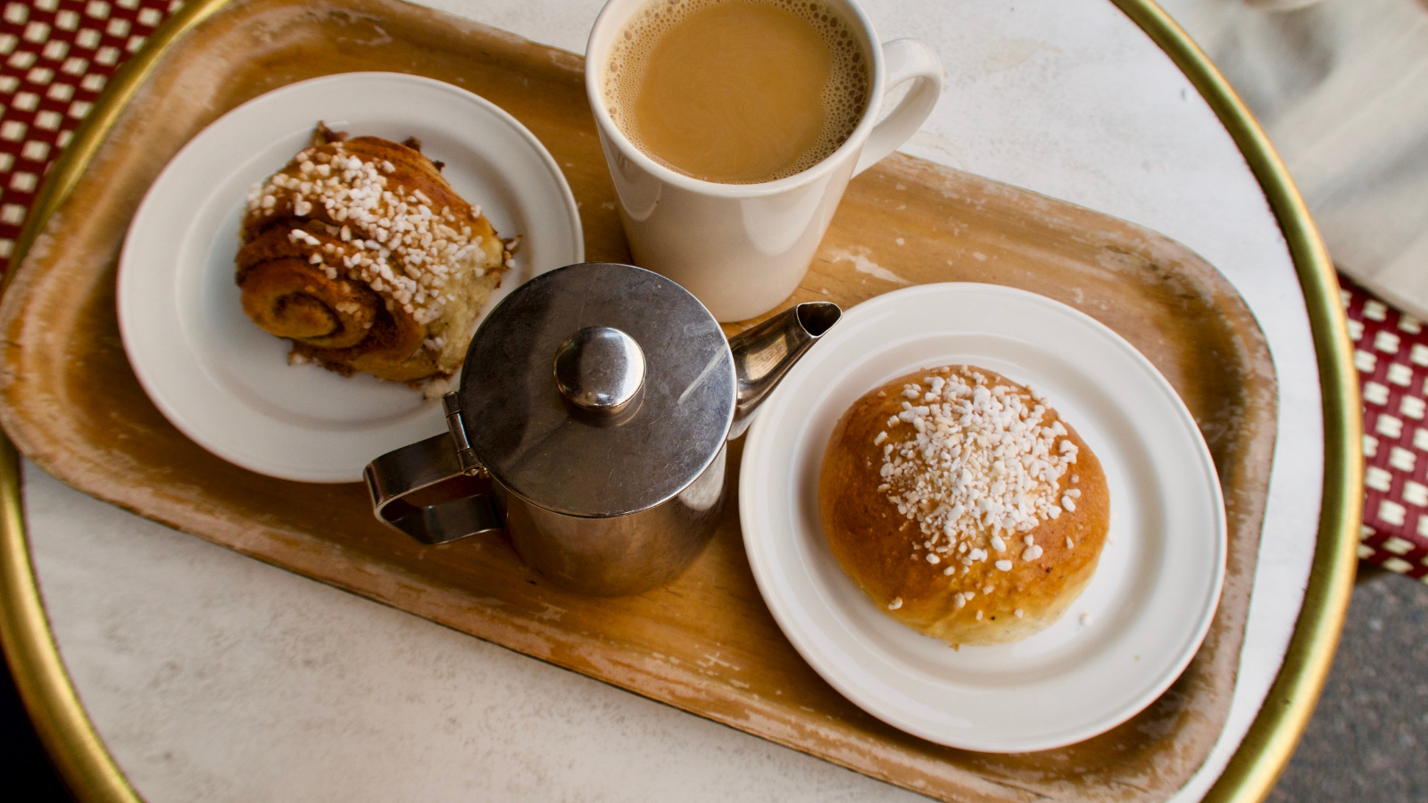 Two pastries, a cup of coffee and a kettle. 