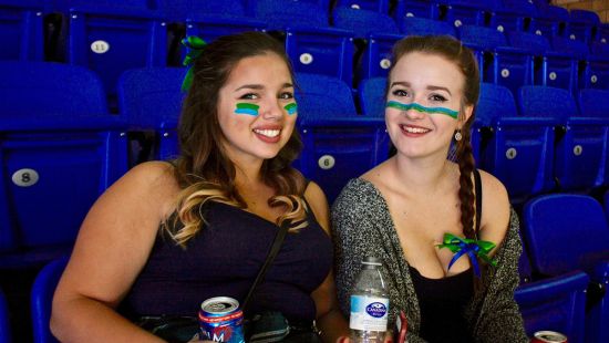 Two people at Hockey game stands