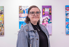 Student Emily Maville stands in front of her art installation at the gallery