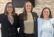 recipients Paige and Macrina stand with local officials after receiving their medals